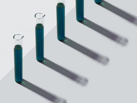 Row of test tubes with liquid, pink background